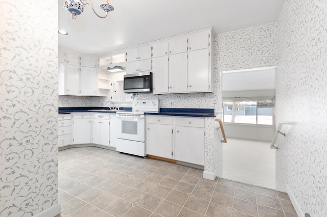 kitchen with white cabinetry, sink, light tile patterned flooring, and white electric range oven