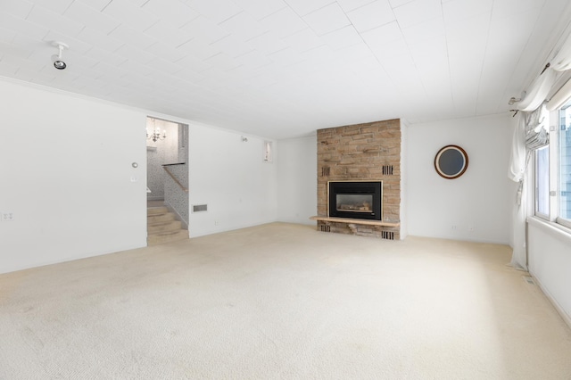 unfurnished living room with a stone fireplace and light colored carpet