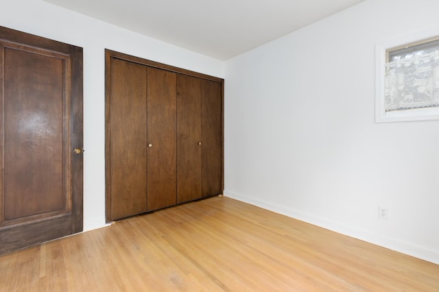 unfurnished bedroom with light hardwood / wood-style flooring and a closet