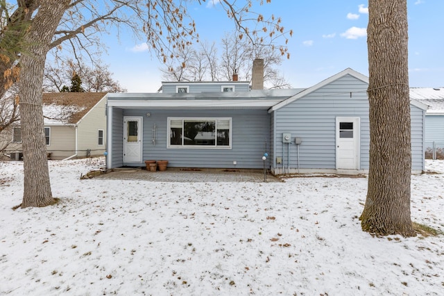 view of snow covered back of property