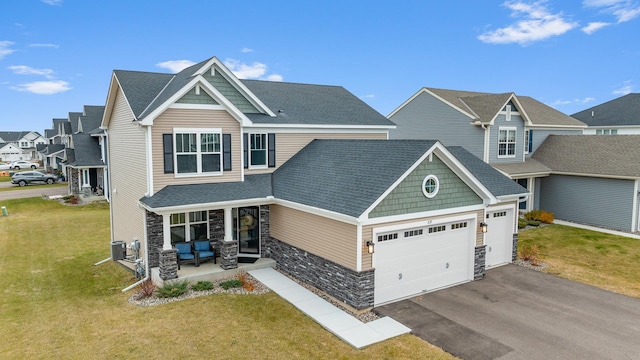 craftsman inspired home featuring a front yard, covered porch, a garage, and central AC unit