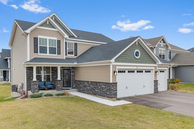 craftsman inspired home featuring covered porch, a front yard, and central air condition unit