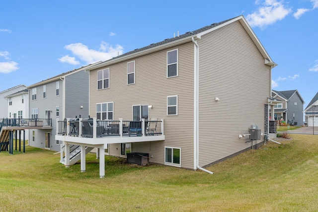 rear view of house featuring a wooden deck, a yard, and central air condition unit