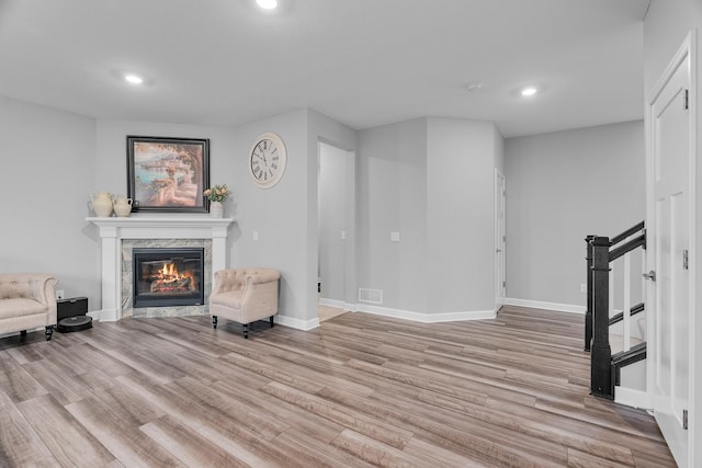 living room with light wood-type flooring and a fireplace