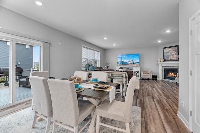 dining area featuring a high end fireplace and light hardwood / wood-style floors