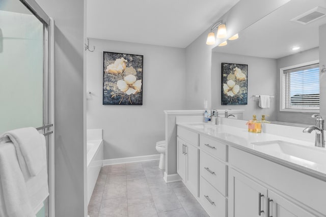 bathroom with tile patterned floors, a tub to relax in, vanity, and toilet