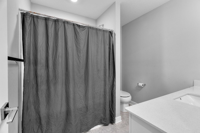 bathroom featuring curtained shower, tile patterned floors, vanity, and toilet