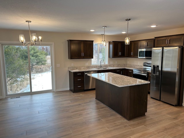 kitchen with stainless steel appliances, hanging light fixtures, a healthy amount of sunlight, and sink