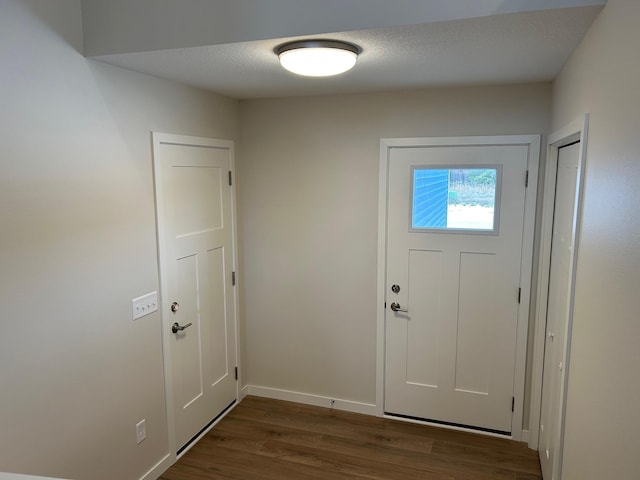 entrance foyer with dark hardwood / wood-style flooring and a textured ceiling