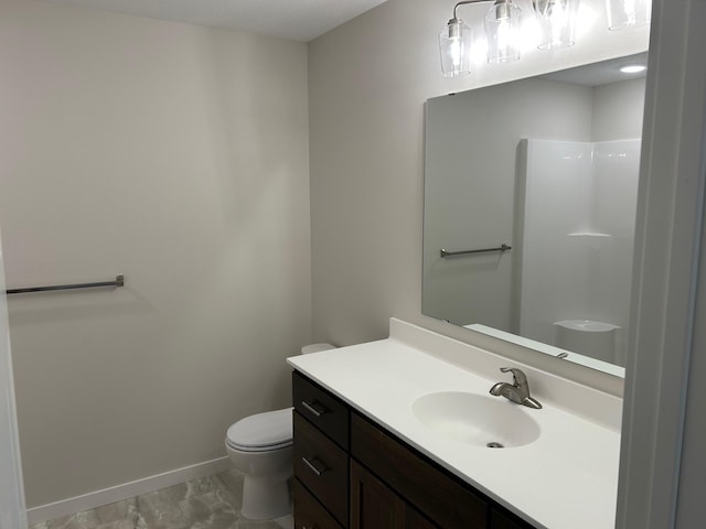 bathroom featuring vanity, toilet, and a shower