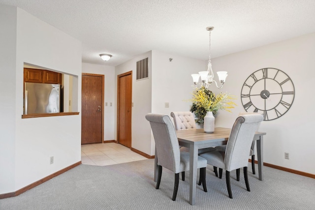 carpeted dining area with a textured ceiling and a notable chandelier