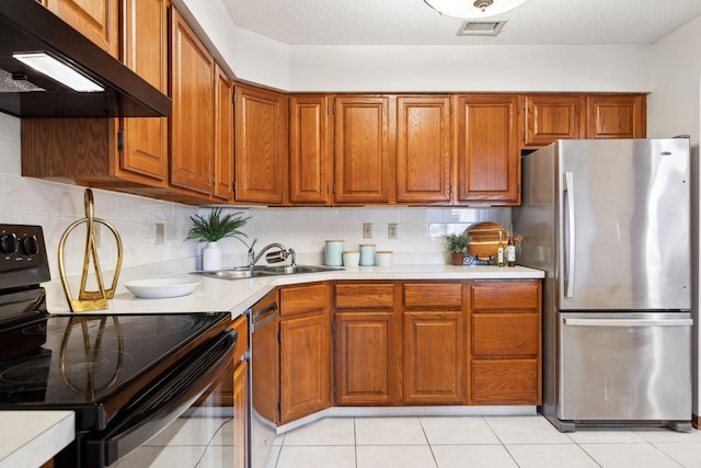 kitchen featuring appliances with stainless steel finishes, tasteful backsplash, light tile patterned floors, and sink