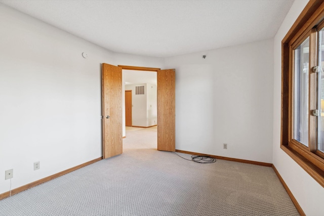 unfurnished room featuring light carpet