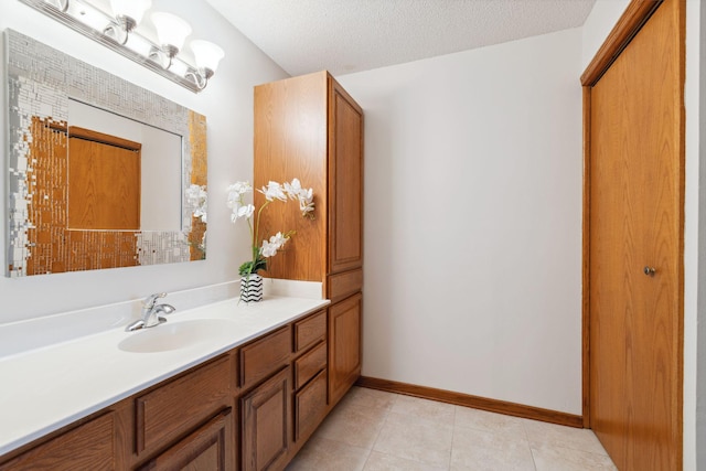 bathroom featuring tile patterned flooring, vanity, and a textured ceiling