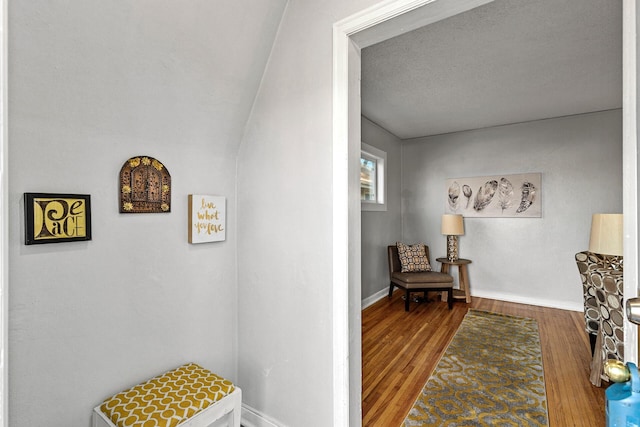 corridor featuring hardwood / wood-style floors and a textured ceiling