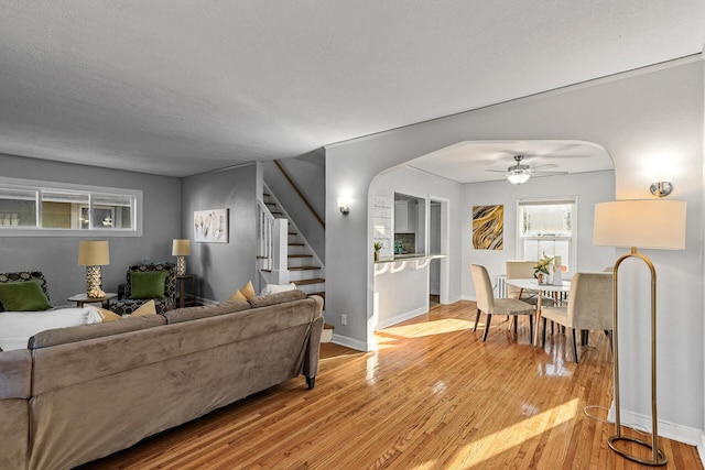 living room featuring a textured ceiling, light hardwood / wood-style flooring, and ceiling fan