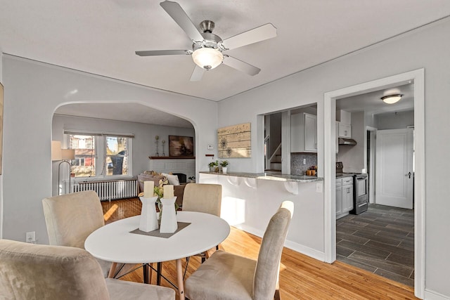 dining space with radiator, ceiling fan, and light hardwood / wood-style floors