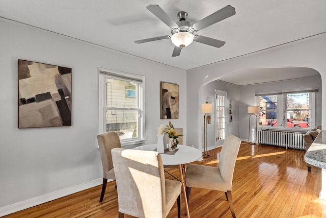 dining room featuring hardwood / wood-style floors, ceiling fan, and radiator heating unit