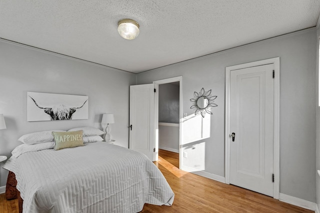 bedroom with hardwood / wood-style floors and a textured ceiling