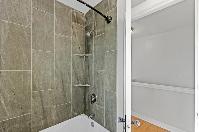 bathroom with tiled shower / bath combo and wood-type flooring