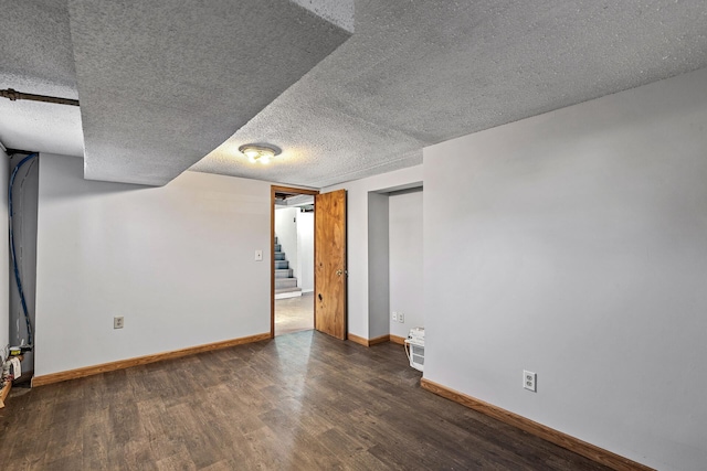 basement with a textured ceiling and dark hardwood / wood-style floors