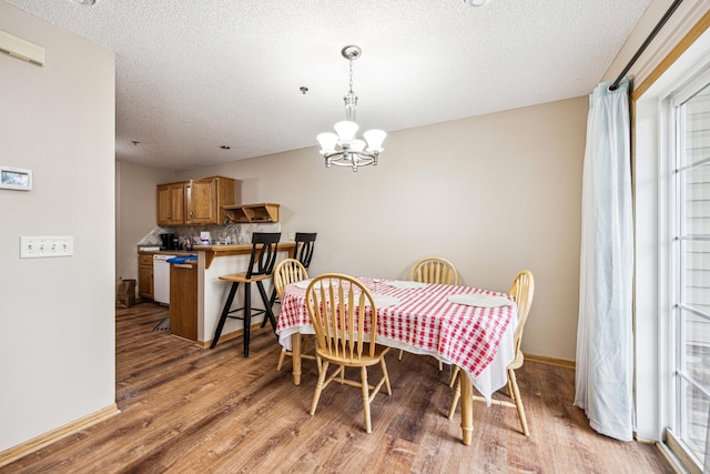 dining space with a chandelier, a textured ceiling, and hardwood / wood-style flooring