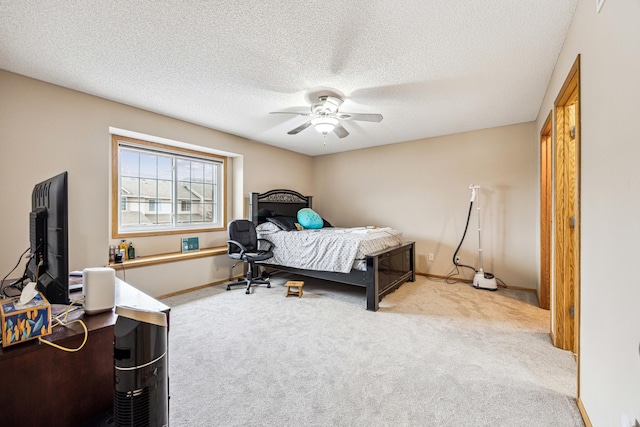 bedroom with a textured ceiling, ceiling fan, and light carpet