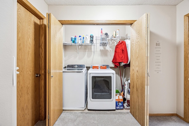 laundry area with carpet flooring, a textured ceiling, and washing machine and clothes dryer