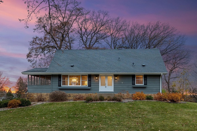 view of front of home with french doors and a lawn