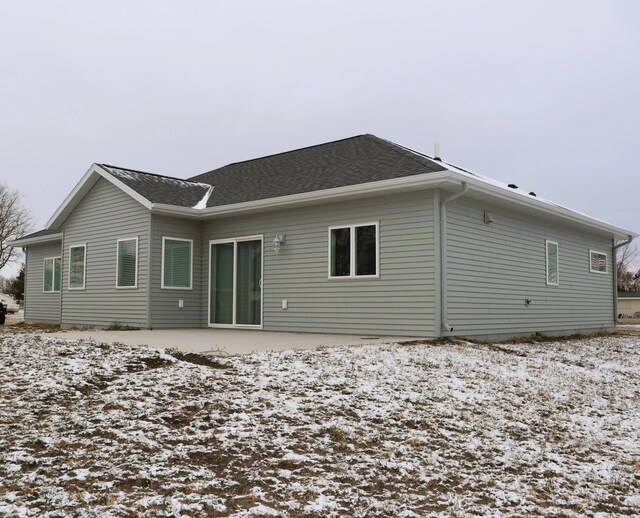 view of snow covered back of property