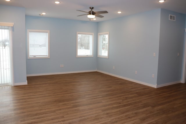 unfurnished room featuring dark hardwood / wood-style floors, a wealth of natural light, and ceiling fan