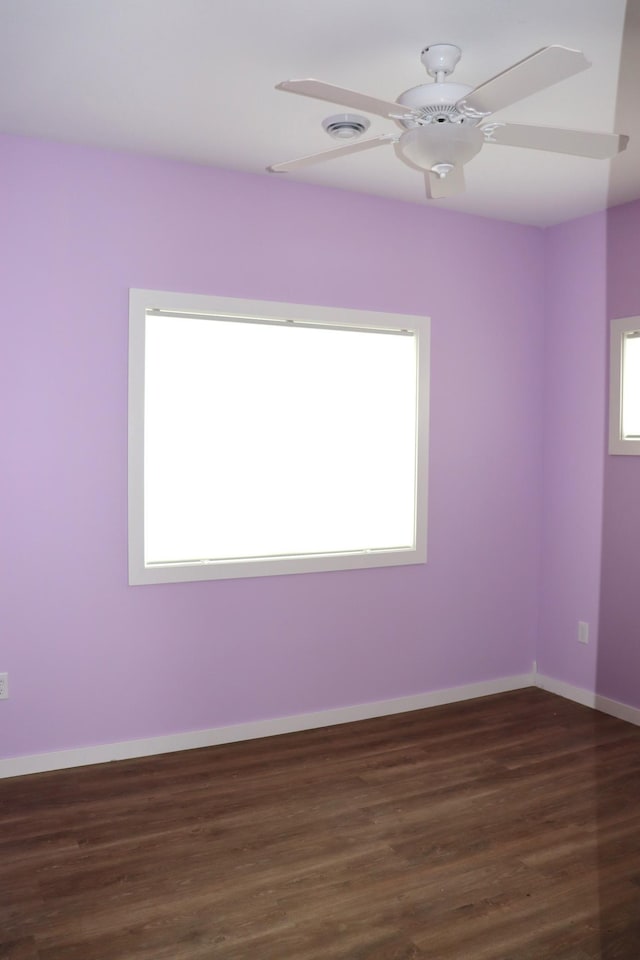 spare room featuring ceiling fan, dark hardwood / wood-style flooring, and a wealth of natural light