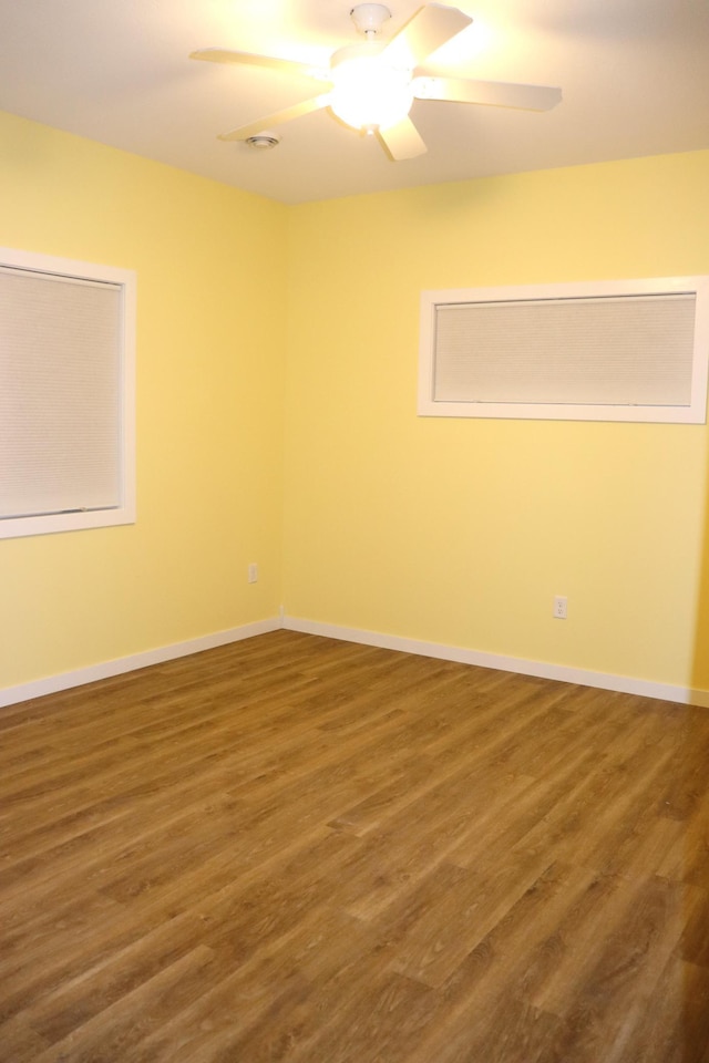 unfurnished room featuring ceiling fan and dark wood-type flooring