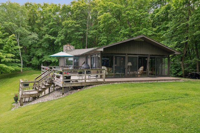 view of front of property featuring a deck, a front lawn, and a sunroom