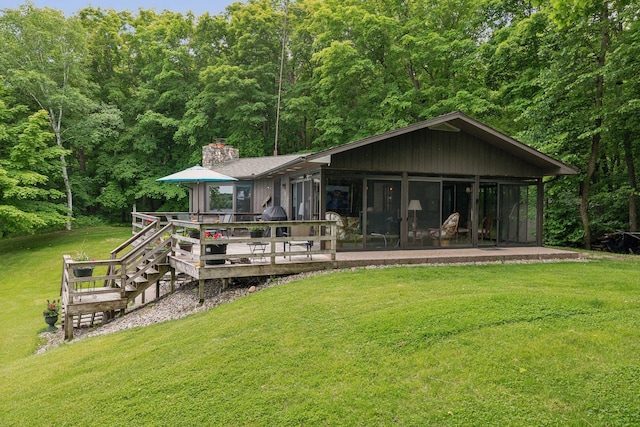 19466 Peninsula Trl, Clitherall Twp, MN 56515 - rear view of property featuring a chimney, a lawn, a wooden deck, and a sunroom