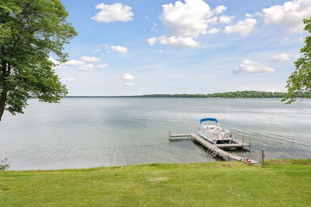 dock area featuring a lawn and a water view