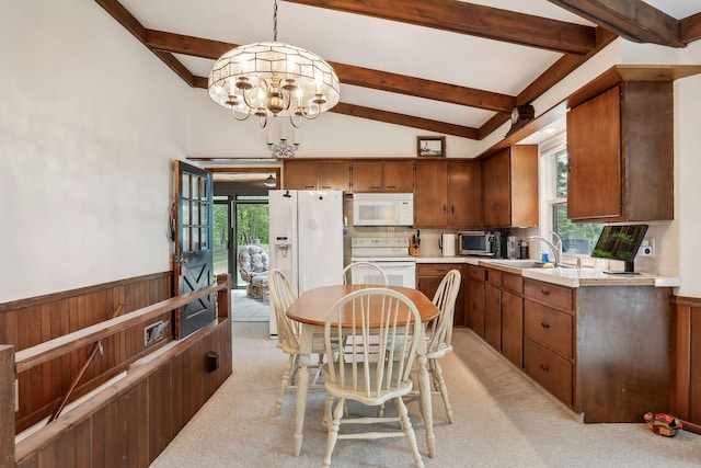 kitchen featuring sink, an inviting chandelier, vaulted ceiling with beams, decorative light fixtures, and white appliances