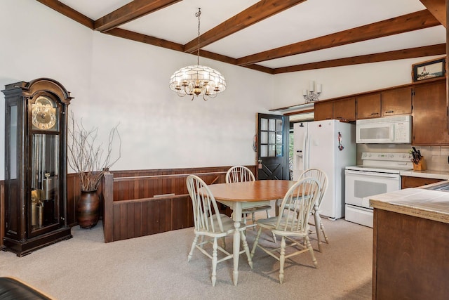 carpeted dining area featuring beamed ceiling and an inviting chandelier