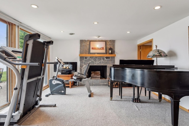 exercise area featuring a fireplace and carpet flooring