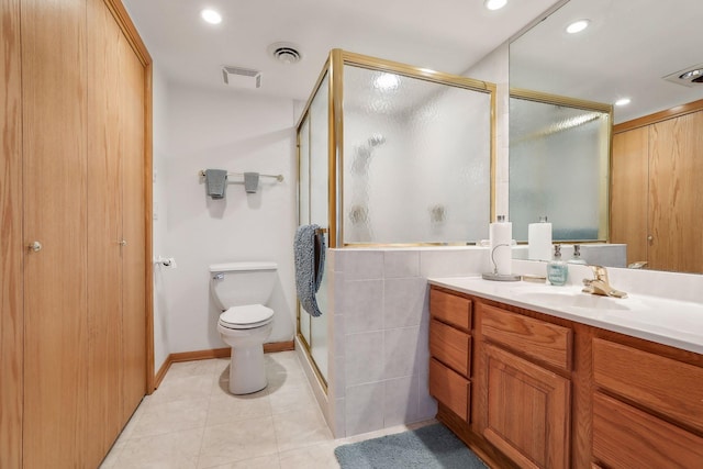 bathroom with tile patterned floors, vanity, toilet, and a shower with door