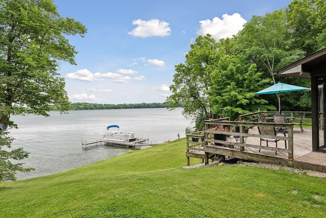 view of dock with a yard and a water view