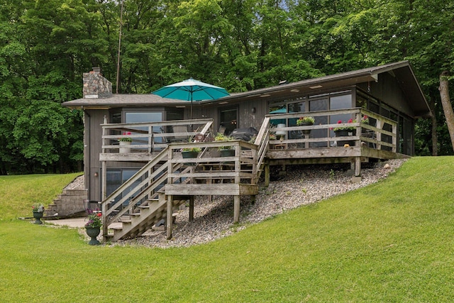 rear view of property featuring a deck and a yard