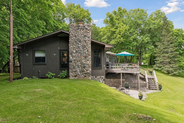 rear view of property with a yard, a patio, and a wooden deck