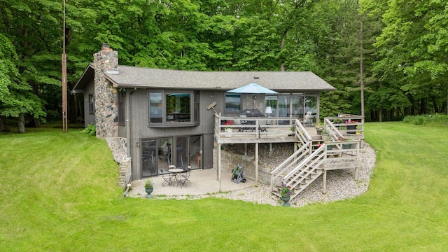 rear view of house with a yard, a patio, a deck, and a sunroom