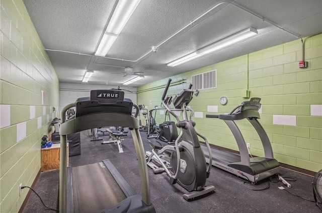 exercise room with a textured ceiling and ceiling fan