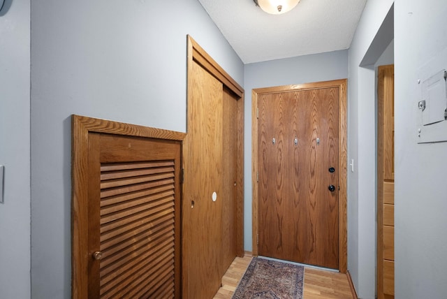 doorway to outside featuring a textured ceiling and light wood-type flooring