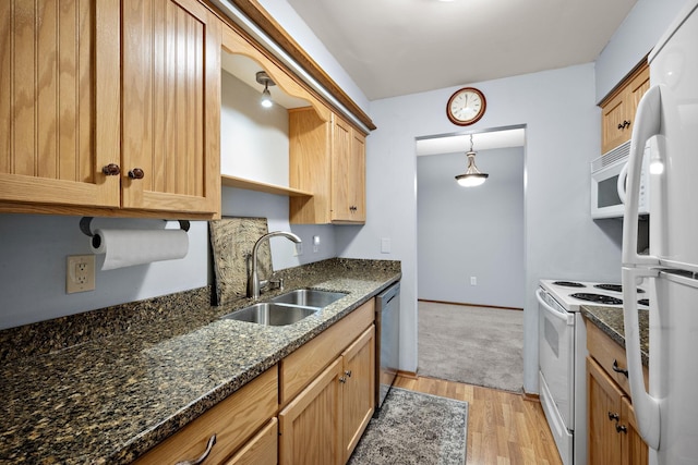 kitchen with white appliances, sink, dark stone countertops, light hardwood / wood-style floors, and hanging light fixtures