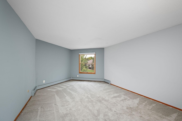 unfurnished room with light carpet and a baseboard heating unit