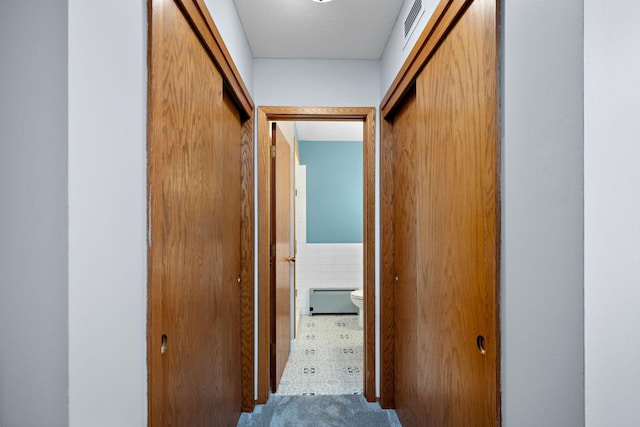 hall with a textured ceiling