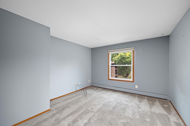 carpeted spare room featuring a baseboard radiator